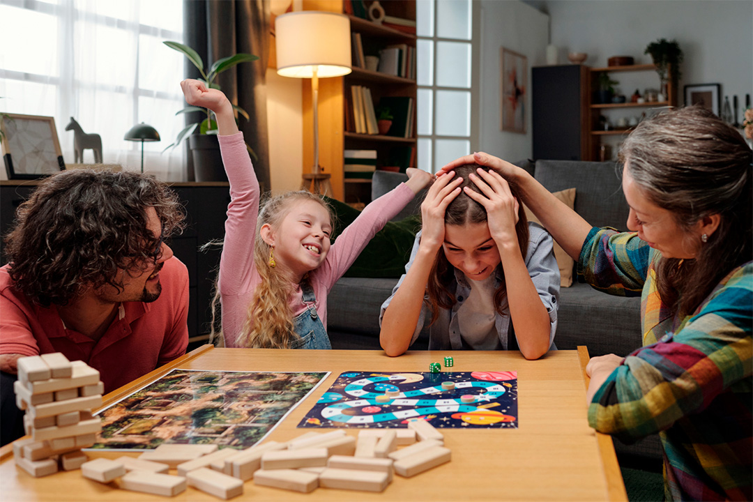 Familia jugando juegos de mesa en la sala, actividad analógica compartida